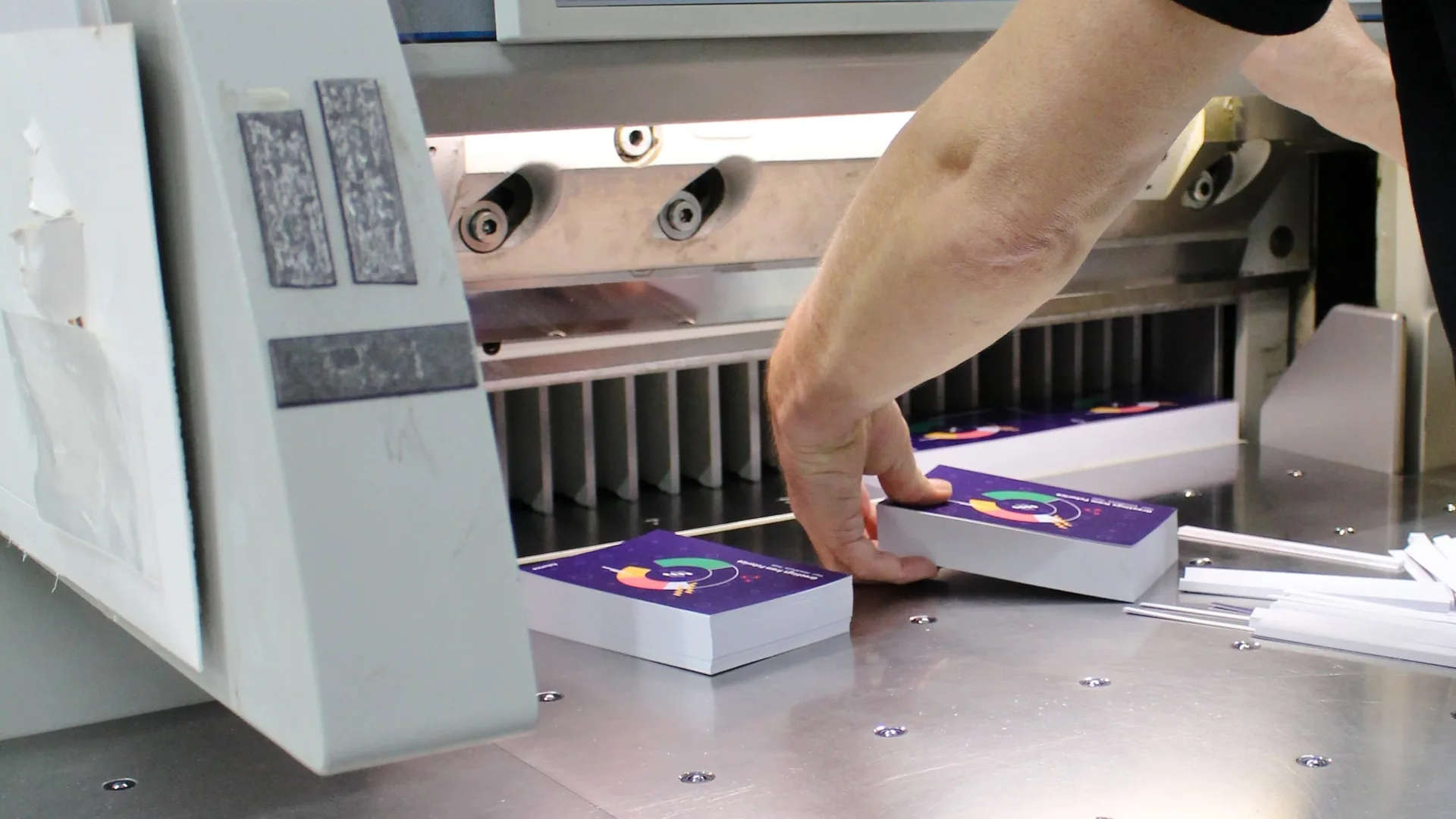 A worker cutting the Data Portrait postcards.